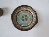a bowl with a decorative design on it next to a decorative object