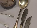 three silver spoons and a knife on a table