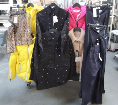 beaucoup de vêtements suspendus à une étagère dans un magasin