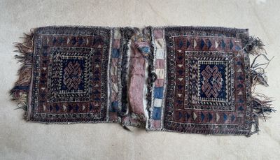 une photo montrant deux morceaux de vieux tapis posés sur une surface blanche