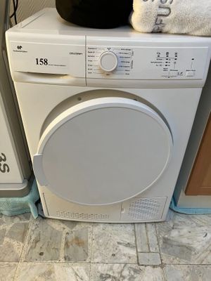 une machine à laver blanche posée sur un sèche-linge