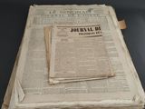 newspapers are stacked on top of each other on a table