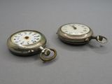 deux montres de poche en argent posées l'une à côté de l'autre sur une table