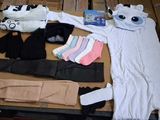a table with a lot of clothing and a stuffed animal
