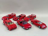 six red toy cars lined up on a white surface