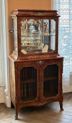 a wooden cabinet with a glass door and a clock on top of it