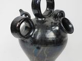 a black vase with three handles on a white background