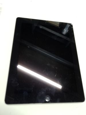 une tablette posée sur une table blanche