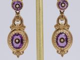 pair of amethorate and diamond earrings on a gold plated stand