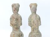 pair of ancient stone figurines of a woman and a man