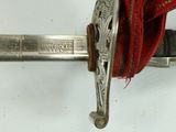 a close up of a sword with a red cloth on it