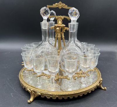 une photo représentant un plateau plaqué or avec des verres et une carafe