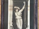 an old picture of a woman in a hat is hanging on a wall