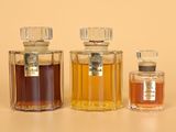 three bottles of perfume sitting next to each other on a table