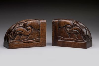 a pair of carved bookends with a bird on a branch