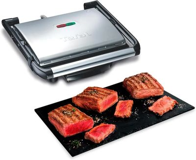 une photo d'un barbecue sur lequel sont disposés des steaks et de la viande
