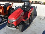 two lawn mowers parked next to each other in a parking lot