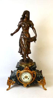 une statue de femme tenant une horloge sur une table
