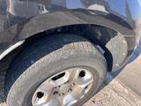 a close up of a car ' s tire on the side of the road