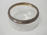 a glass jar with a gold rim sitting on a table