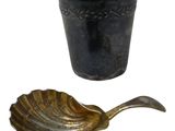 a black cup and a gold spoon next to each other