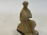 an image of a statue of a man sitting on top of a table