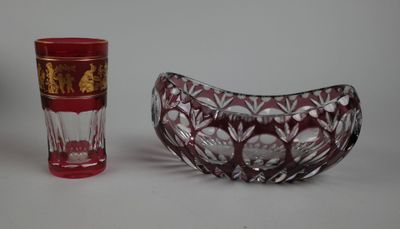 un bol en verre rouge et une tasse en verre rouge posés l'un à côté de l'autre