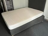 un lit sur lequel est posé un matelas dans une pièce