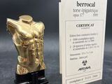 a gold statue of a torso next to a business card
