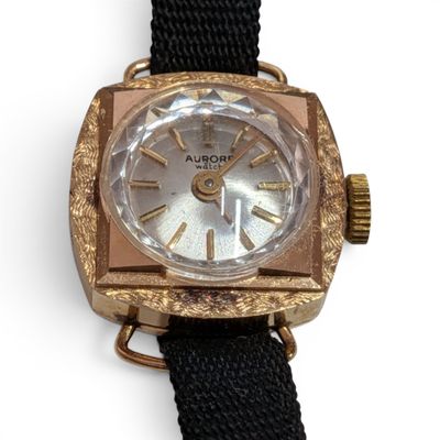 a close up of a watch on a white surface