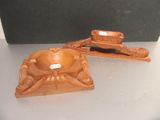 pair of carved wood ashtrays on a table with a black background