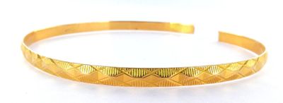 a close up of a gold bracelet on a white surface