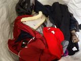 a pile of clothes and a helmet on a bed
