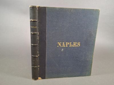 un vieux livre posé sur une table à côté d'un mur blanc