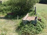 a bench in the middle of a field next to a tree