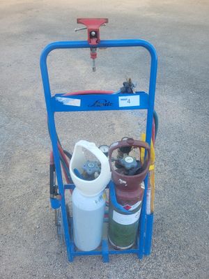 un chariot bleu sur lequel se trouvent deux bouteilles de gaz et un tuyau