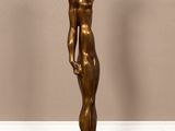 a bronze statue of a woman standing on a black base