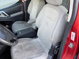 the interior of a red car with two seats and a steering wheel