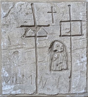 a stone plaque with a picture of a man holding a cross