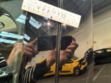 a man taking a picture of a car in a mirror