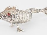 un poisson argenté aux yeux rouges posé sur une surface blanche