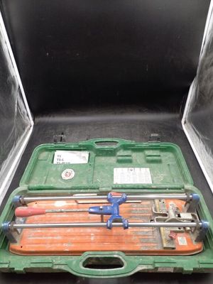 une mallette verte contenant des outils, posée sur une table
