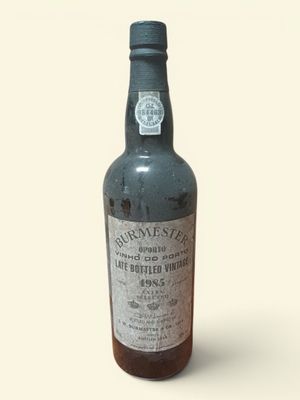 une vieille bouteille de rhum posée sur une surface blanche