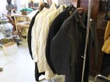 a lot of coats hanging on a rack in a room