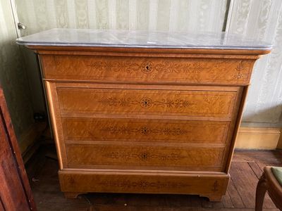 a wooden dresser with marble top in a room