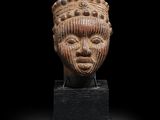 un gros plan d'une sculpture représentant une tête sur une surface noire