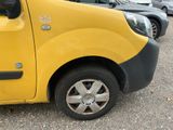 a yellow van parked in a parking lot with other cars