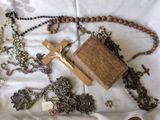 une croix, un chapelet et d'autres objets religieux disposés sur un lit