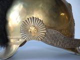 a gold helmet with a black fur on it