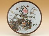 une assiette décorative ornée d'un oiseau et de fleurs
